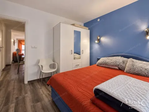 Namještena spavaća soba sa bračnim krevetom, bijelim ormarom i plavim zidom. - image 11