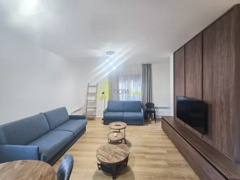 Spacious living room with sofa set, wooden coffee tables and a wall-mounted TV. - image 2