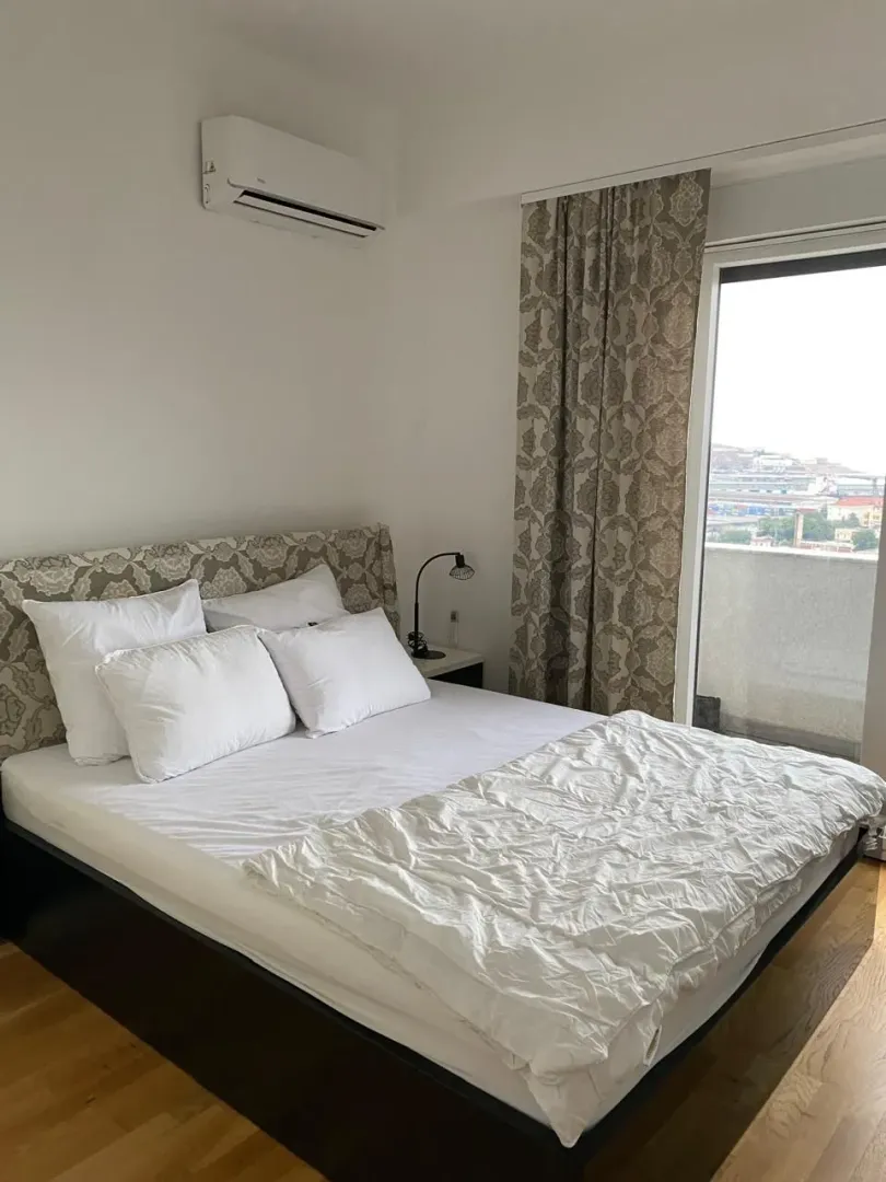 Spavaća soba sa bračnim krevetom, klima uređajem i izlazom na terasu.
