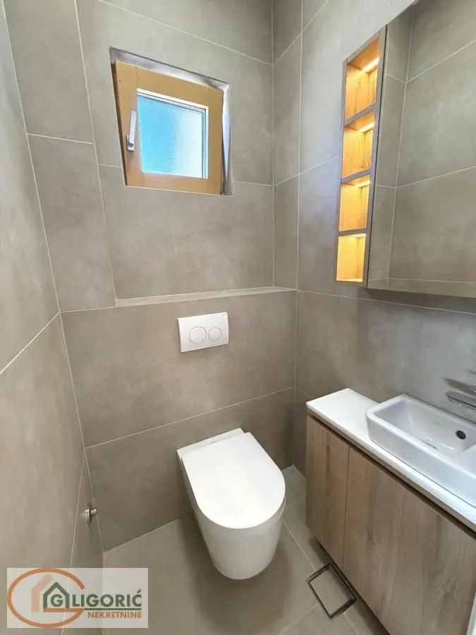 Modernly equipped bathroom with a toilet and a sink.