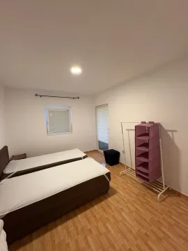 Bedroom with two beds and a wardrobe. - image 14