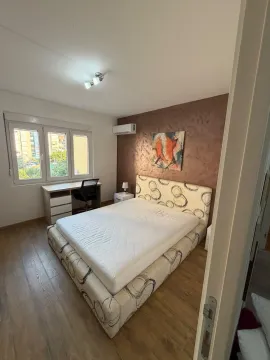 Furnished bedroom with a double bed, desk, and a window. - image 7