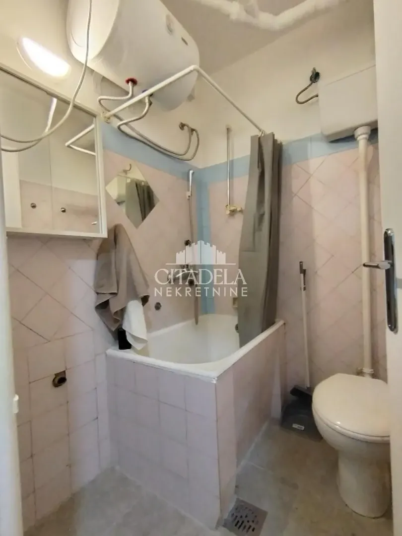 Manje kupatilo sa kadom, wc šoljom i bojlerom.