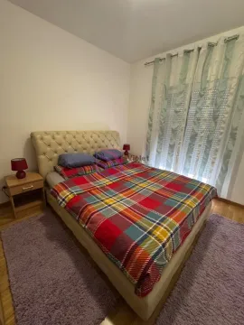 Bedroom with a double bed, nightstands, and a window with curtains. - image 6