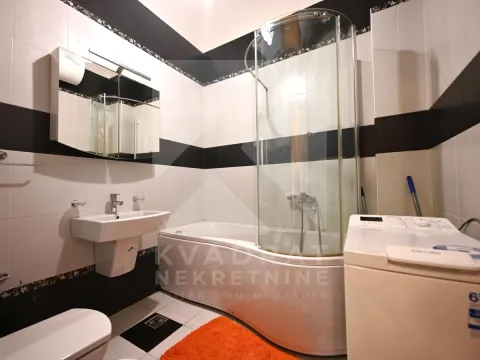 Bathroom with a bathtub, shower cabin, washbasin, and washing machine. - image 11