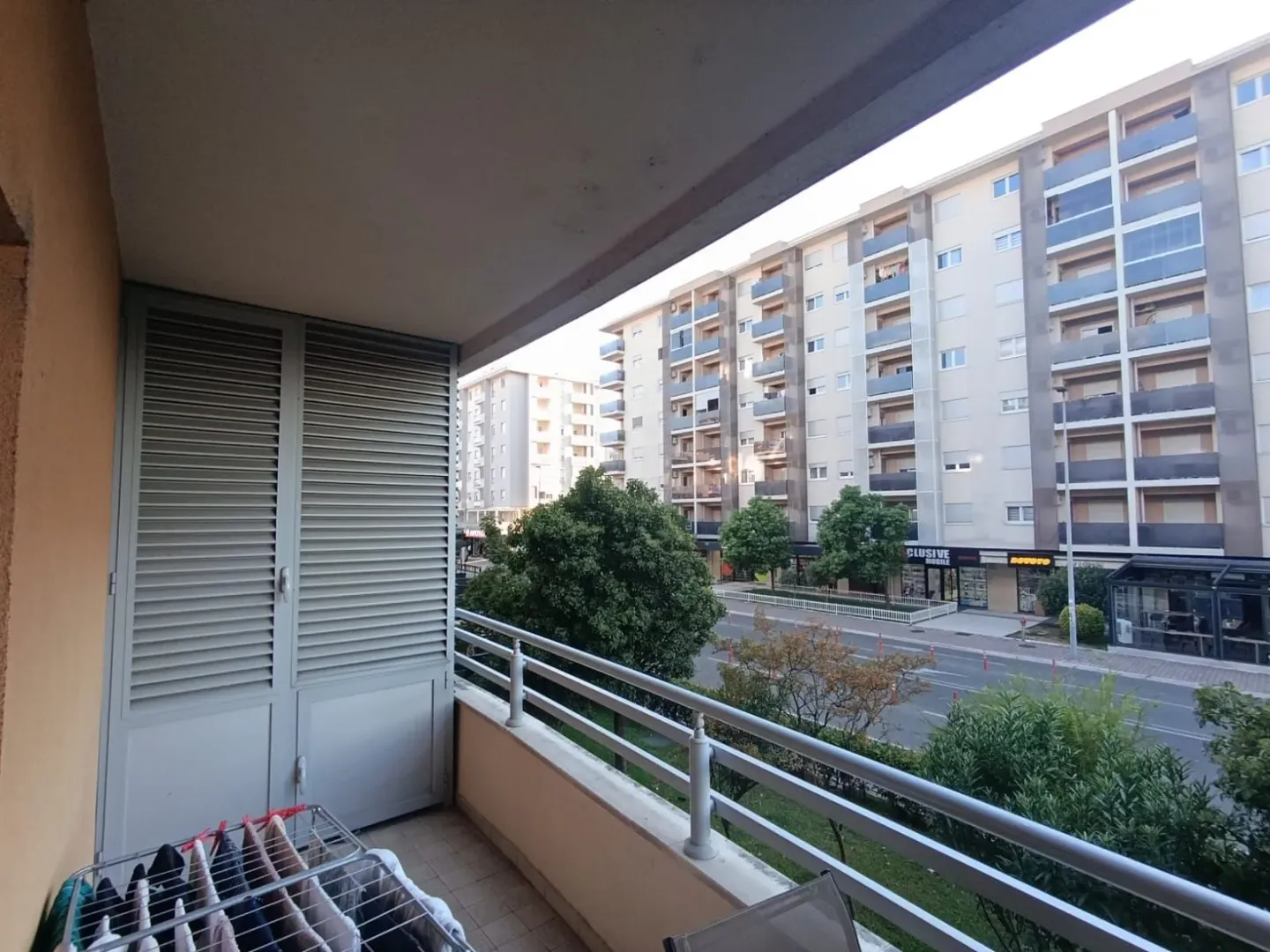 Pogled sa balkona na okolne stambene zgrade i ulicu.