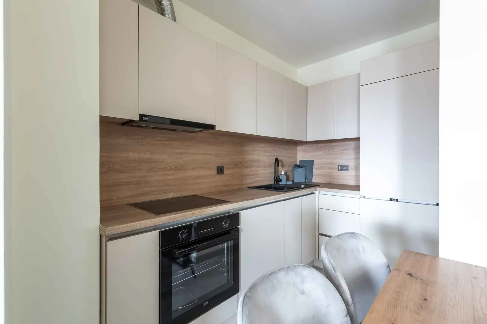 Modern kitchen with built-in appliances and a dining table.
