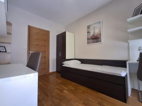 Furnished bedroom with a bed, wardrobe, and desk. - image 9