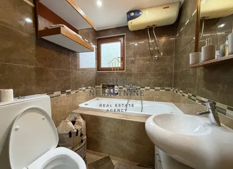 Compact bathroom tiled in brown with a bathtub, toilet, and sink. - image 18