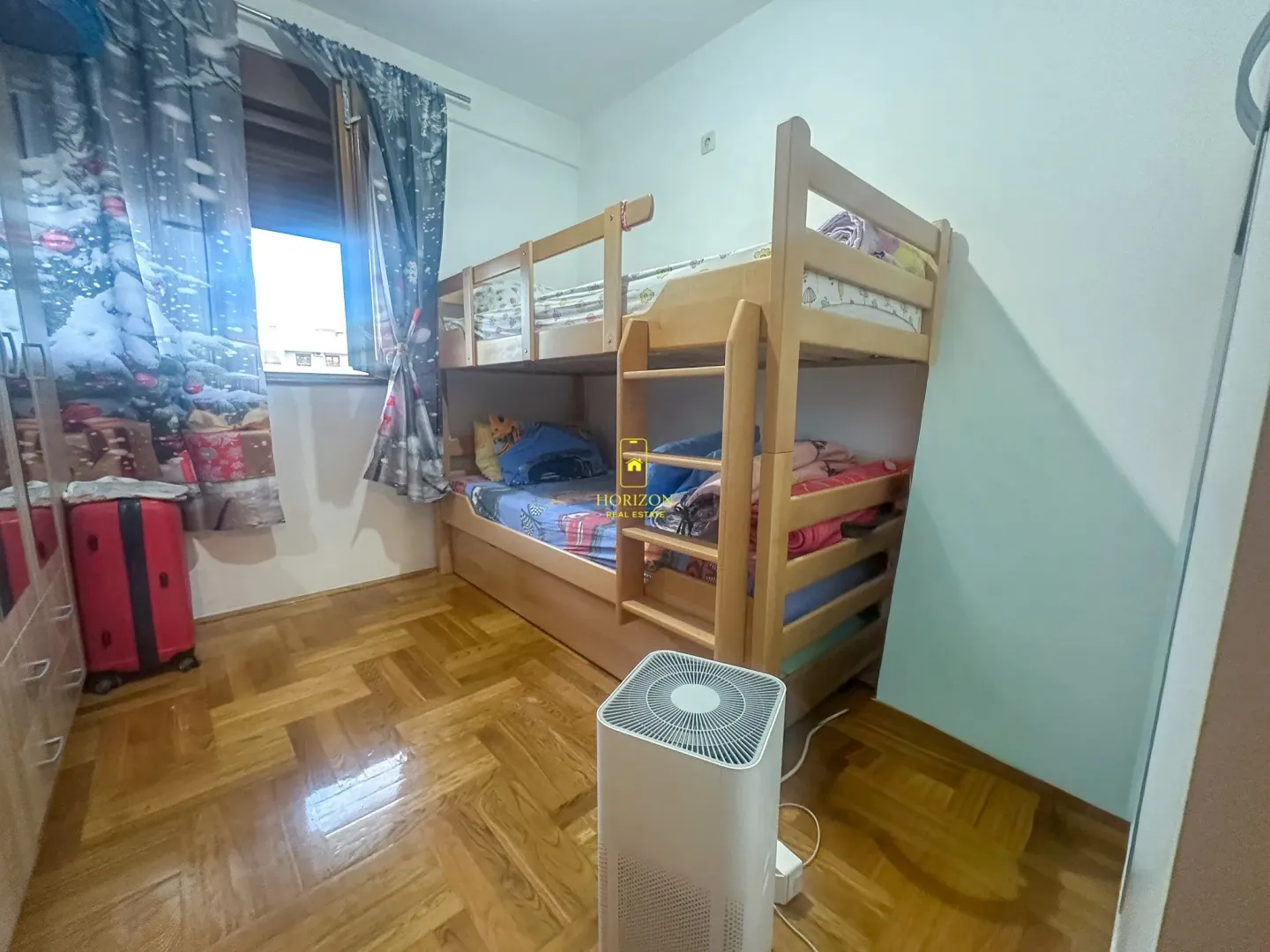 Dječija soba sa drvenim krevetom na sprat i parketom na podu.