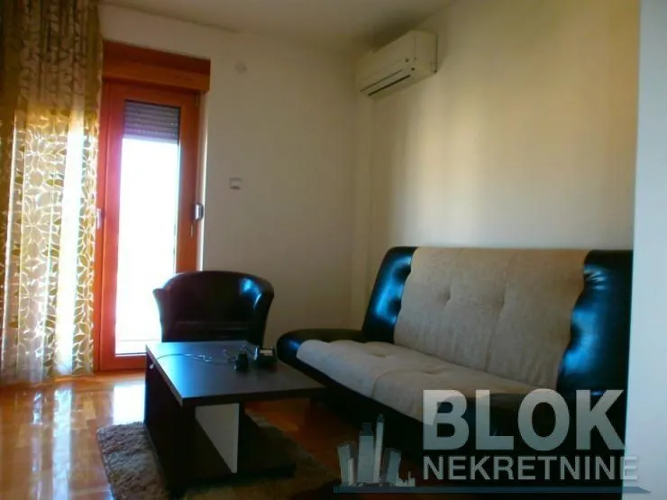 Living room with sofa, coffee table and access to the terrace.