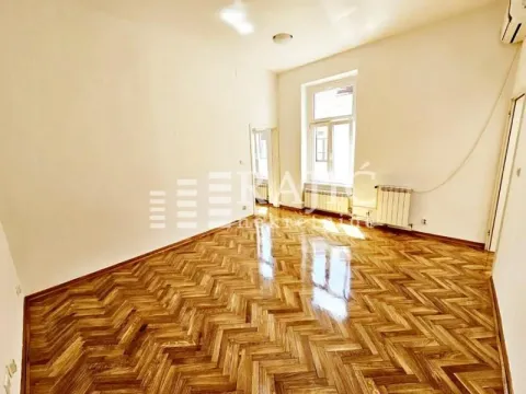 Empty room with parquet flooring and a large window. - image 15