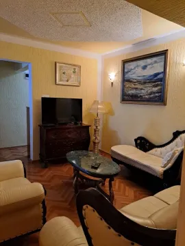Dnevna soba opremljena namještajem, televizorom i umjetničkim slikama na zidu. - image 2