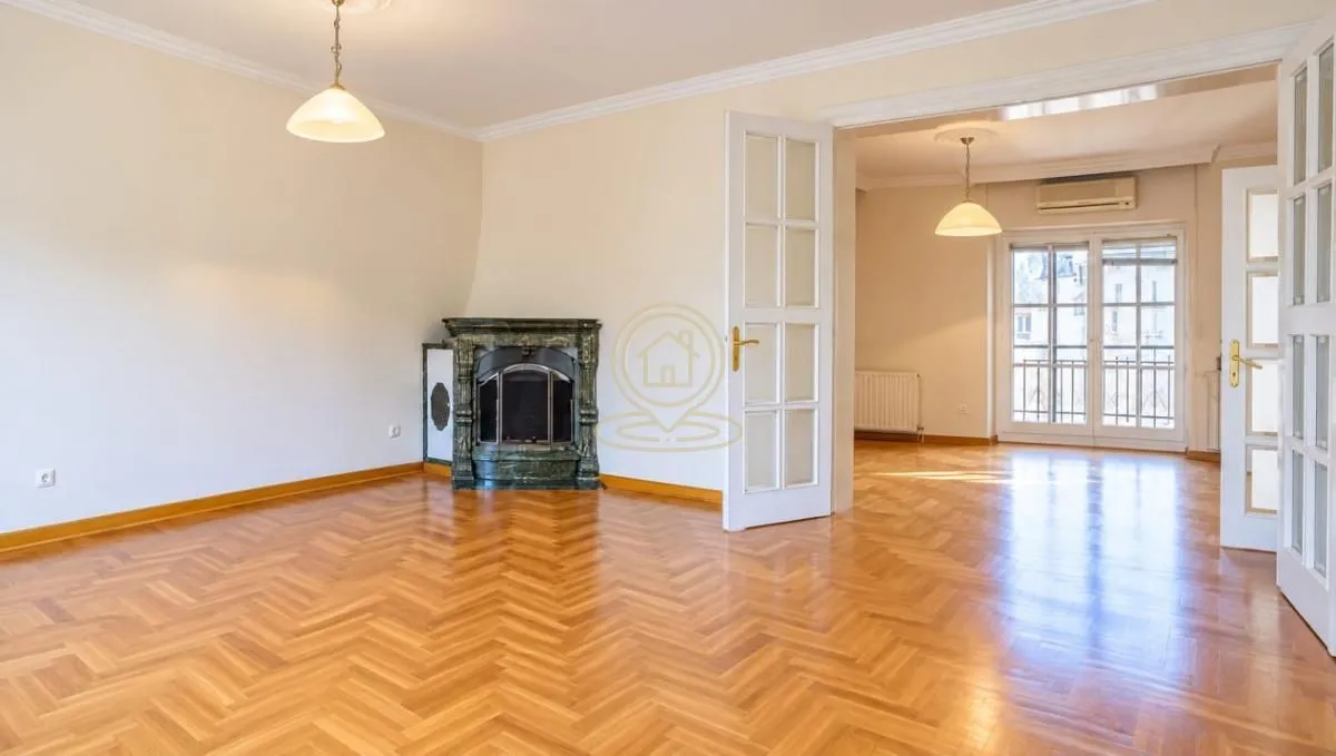 Spacious living room with a fireplace and hardwood parquet flooring.