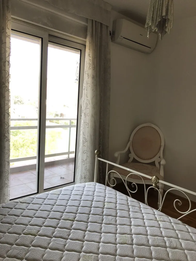 Bright bedroom with access to a balcony and a classic armchair.
