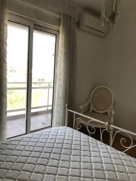 Bright bedroom with access to a balcony and a classic armchair. - image 21