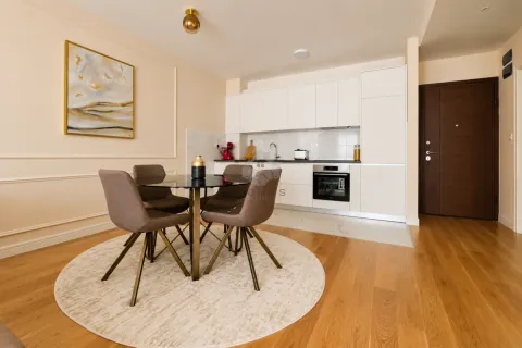 Modern kitchen with dining area and built-in appliances. - image 18