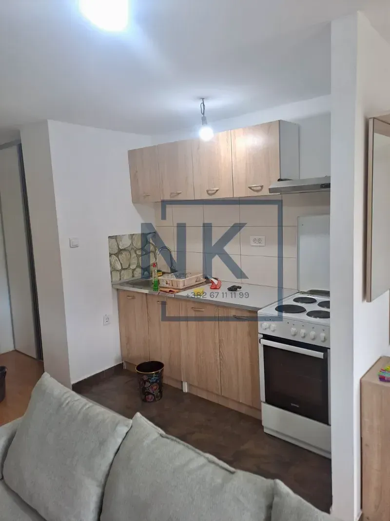 Smaller kitchen with wooden elements connected to the living room.
