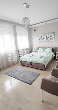 Tidy bedroom with a double bed, windows, and modern lighting. - image 16