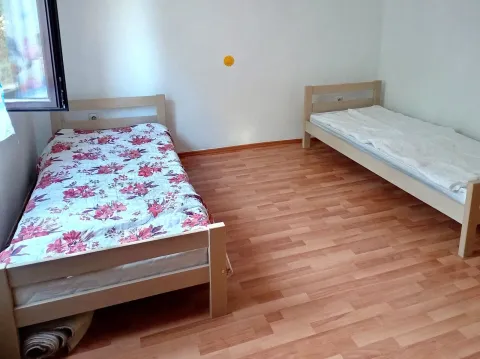 Bedroom with two wooden beds and laminate flooring. - image 5
