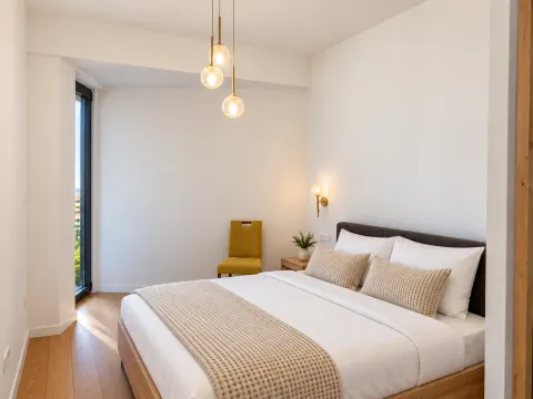 Bright and tidy bedroom with a double bed and wooden flooring. - image 11