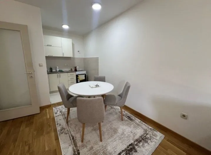 Manja kuhinja sa trpezarijskim stolom i četiri stolice.