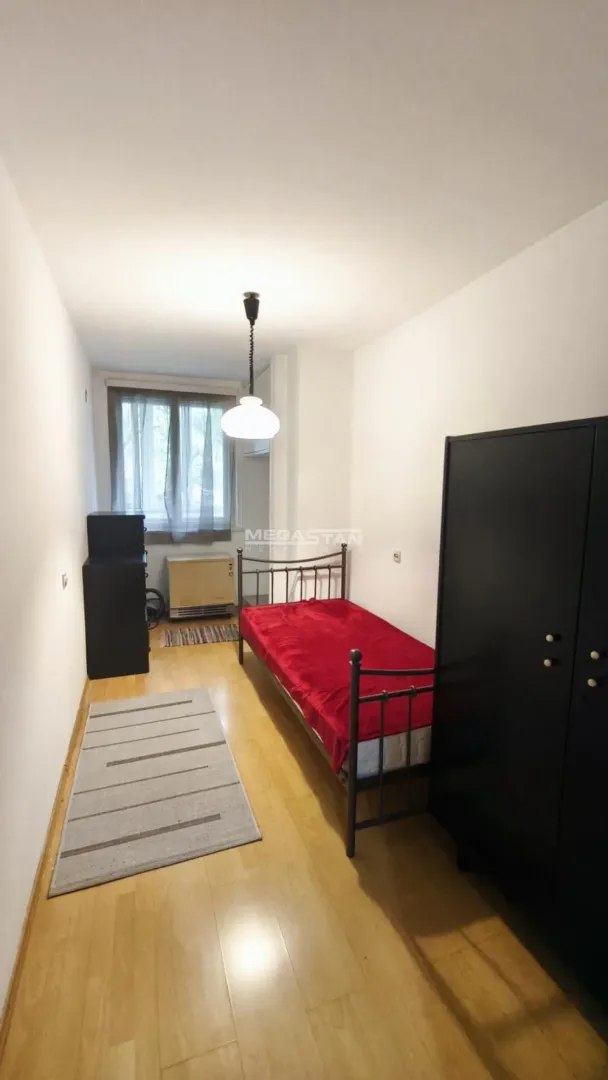 Manja spavaća soba sa krevetom i ormarom.