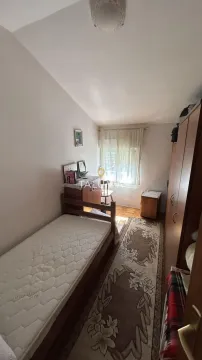 Manja spavaća soba sa krevetom, garderobom i prozorom. - image 2