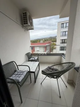 Namešten balkon sa garniturom za sedenje i pogledom na okolinu. - image 16