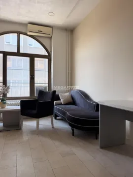 Living room with furniture and a large arched window. - image 2