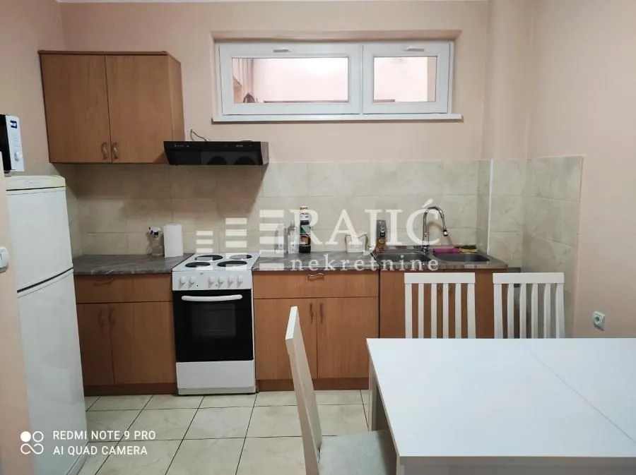 Smaller kitchen with wooden cabinets and a dining table.
