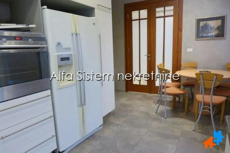Kitchen with a white refrigerator and a dining table in the background.