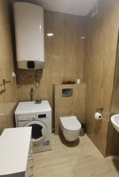 Modernly equipped bathroom with a washing machine and built-in elements. - image 5
