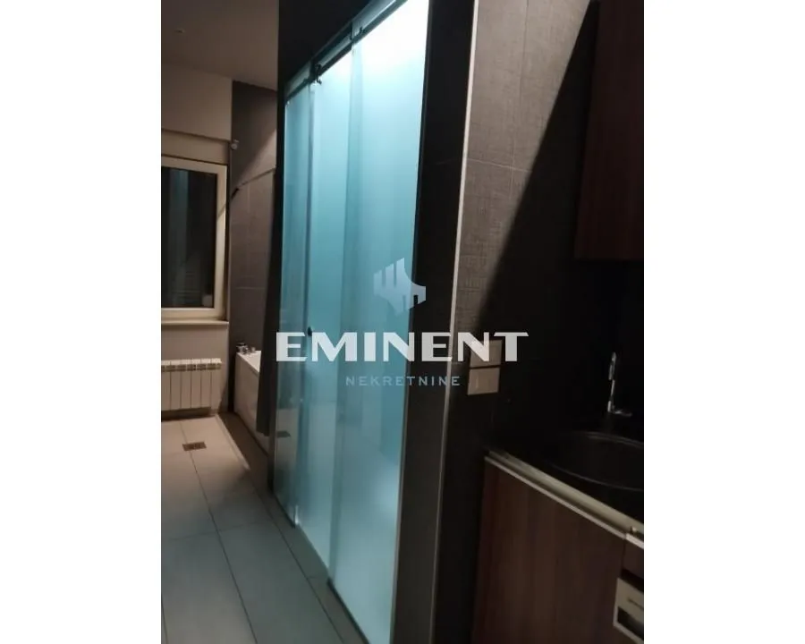 View of the bathroom with a shower enclosure and sink.