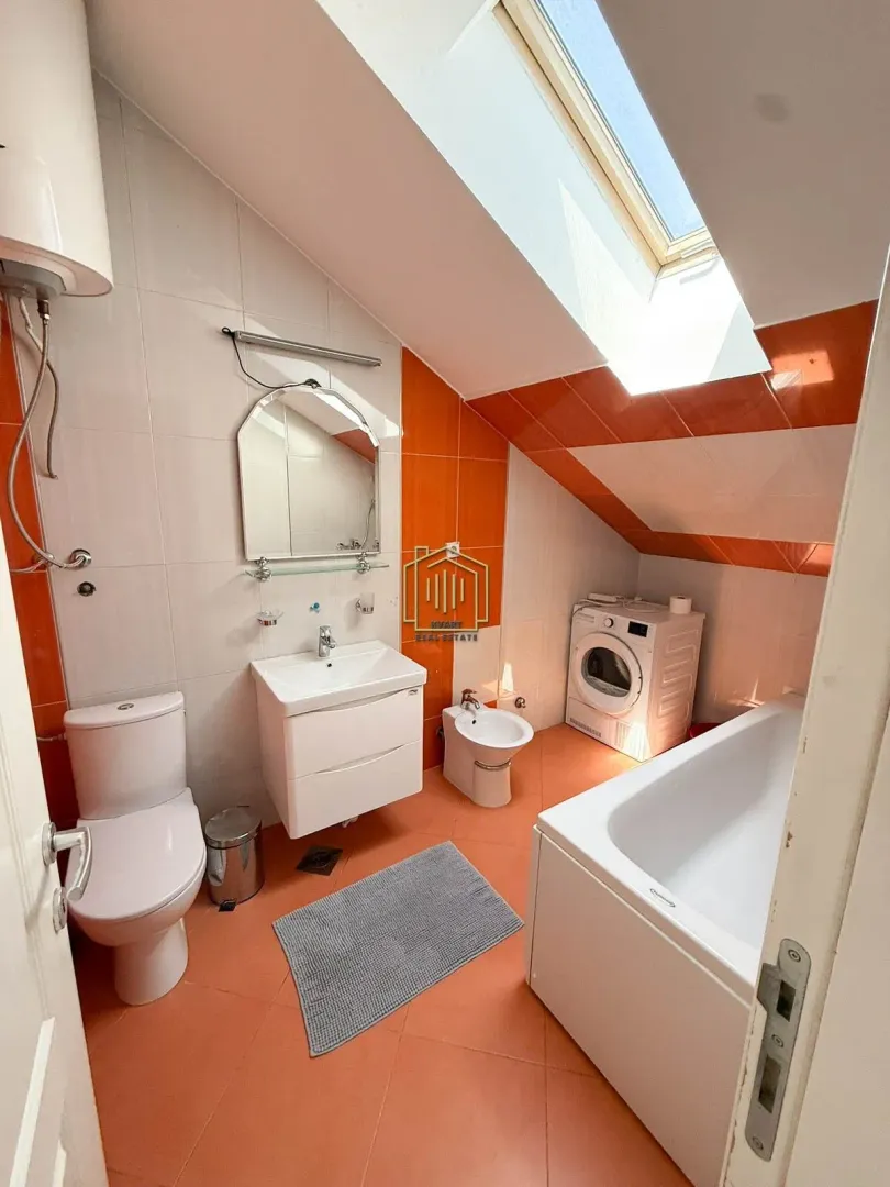 Bathroom with a bathtub, washbasin, toilet, bidet, and washing machine.