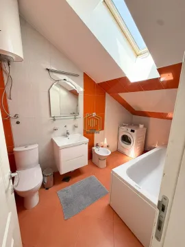 Bathroom with a bathtub, washbasin, toilet, bidet, and washing machine. - image 2