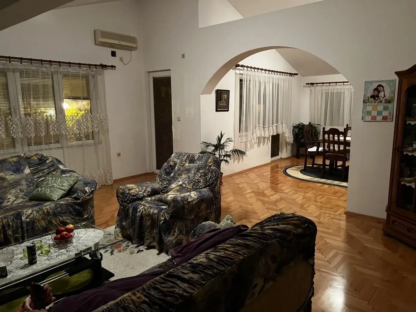 Dnevna soba sa garniturom za sjedenje i trpezarijom u pozadini.
