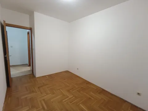Prazna soba sa bijelim zidovima i parketom na podu. - image 6
