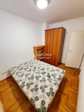 Furnished bedroom with a double bed, wooden wardrobe, and parquet flooring. - image 8