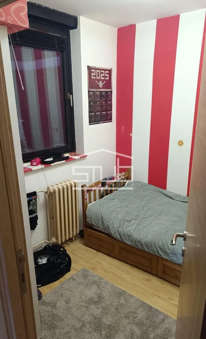 Small bedroom with a bed and a window.