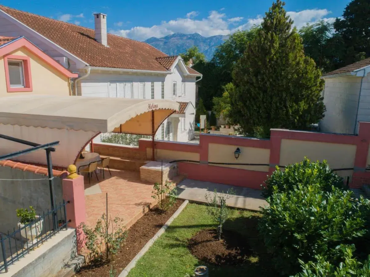 Pogled na dvorište sa terasom i natkrivenim dijelom u sklopu kuće.