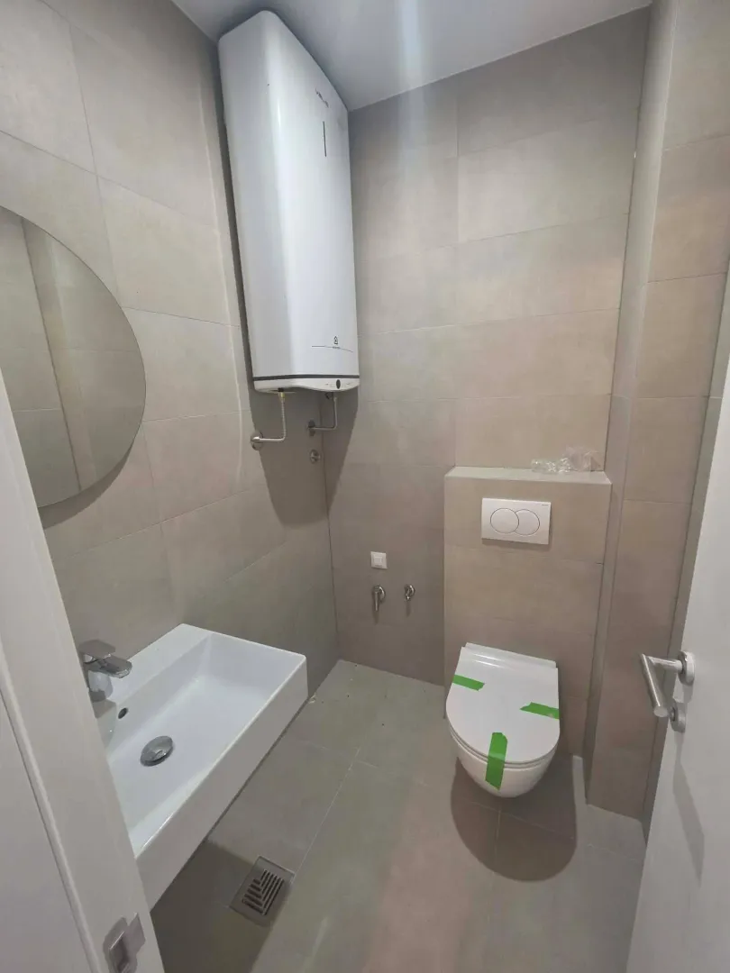 Modern bathroom equipped with a shower drain and water heater.