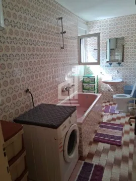 Bathroom with a bathtub, washbasin, toilet, and washing machine. - image 5