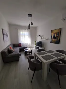 Living room with a sofa, TV, and dining table with chairs. - image 4