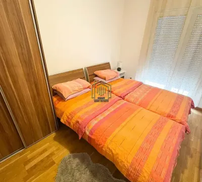 Namještena spavaća soba sa dva kreveta i ugradnim ormarom. - image 9