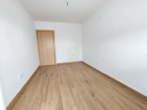 Prazna soba sa belim zidovima i drvenim podom. - image 4