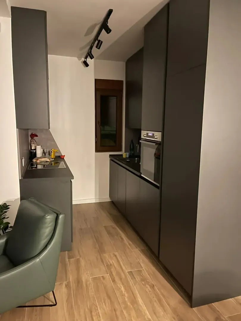 Modern kitchen with dark cabinets and a built-in oven.