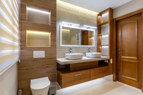 Moderno opremljeno kupatilo sa drvenim elementima, dva umivaonika i wc šoljom. - image 24
