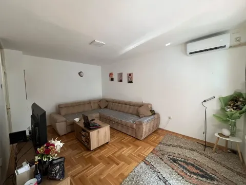 Living room with a sectional sofa, coffee table, and parquet flooring. - image 12