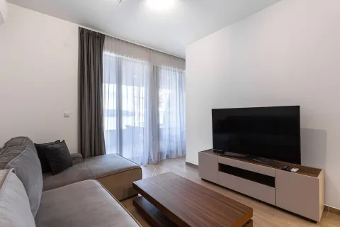 Dnevna soba sa ugaonom garniturom, televizorom i izlazom na terasu. - image 9